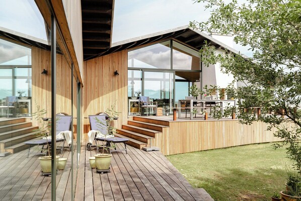 A modern house with a deck, outdoor seating, and large windows. - Architect-designed gem with views of Venø Bay (Vinderup)