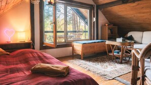 Una habitación acogedora con una cama, un escritorio, una silla y una ventana con vistas a una terraza.