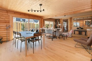 Ein Holzblockhaus-Innenraum mit Essbereich, Küche und Sitzgelegenheit.