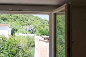 A view through a window with a mountain and buildings in the background. - Cucca's Home - Three Bedroom Apartment, Sleeps 5 (Siniscola)