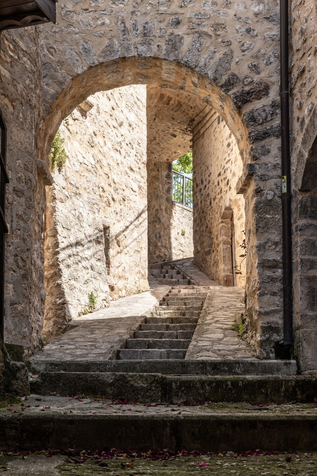 Eine steinerne Treppe führt durch einen Bogen in ein historisches Gebäude.