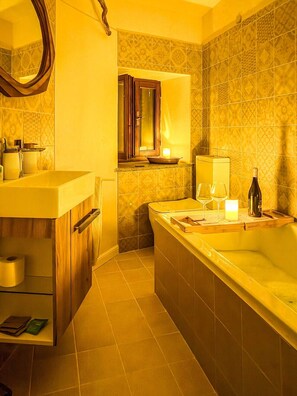 Ein Badezimmer mit Badewanne, Toilette, Waschbecken und Spiegel.