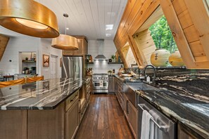 Eine moderne Küche mit einer zentralen Kochinsel, Edelstahlgeräten und Holzelementen.