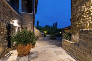 Ein gepflasterter Innenhof mit einem Blumentopf, einer Treppe und einem Gebäude mit einer Steinaußenwand.