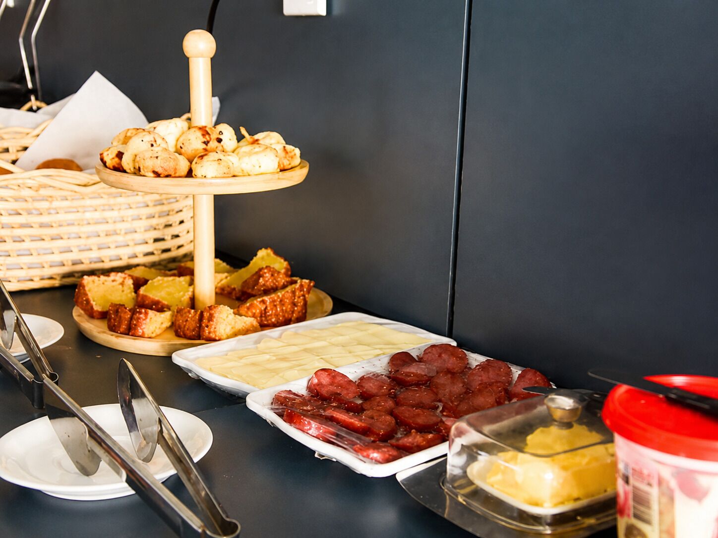 A buffet table with various food items, including pastries, bread, and meats.