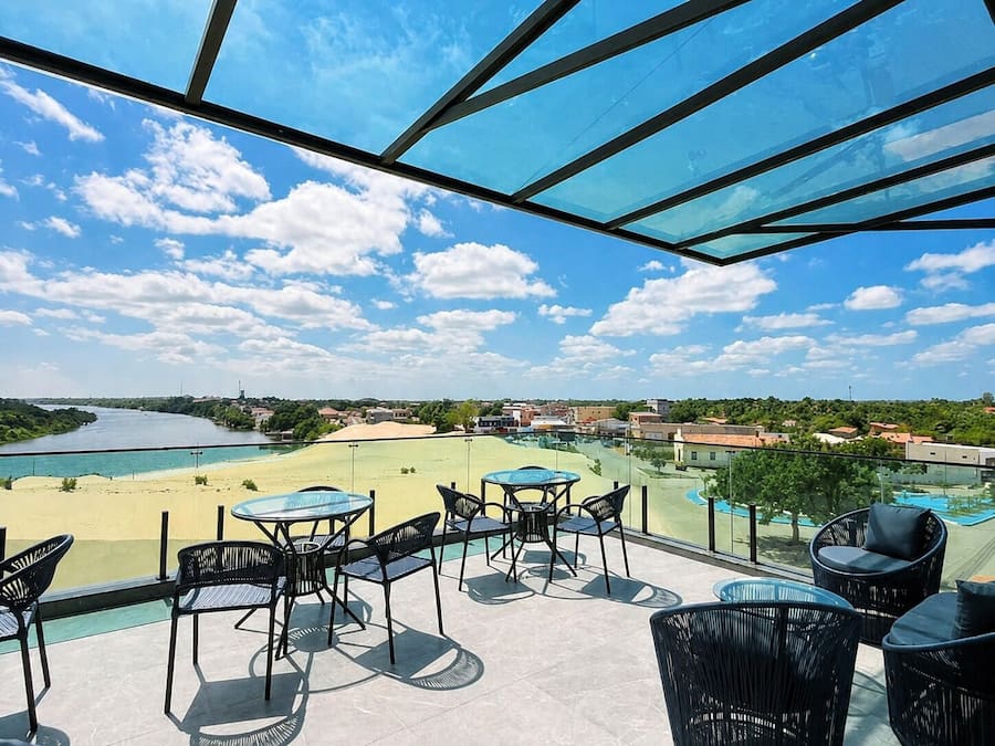 Una terraza con mobiliario exterior, vistas a un río y una piscina.