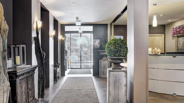 Un moderno vestíbulo de hotel con un pasillo central, una recepción y un amplio ventanal.