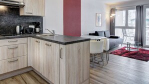 Una cocina moderna con armarios de madera, encimera negra y estufa integrada.