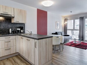 Eine moderne Küche mit Holzschränken, einer schwarzen Arbeitsplatte und einem eingebauten Herd.