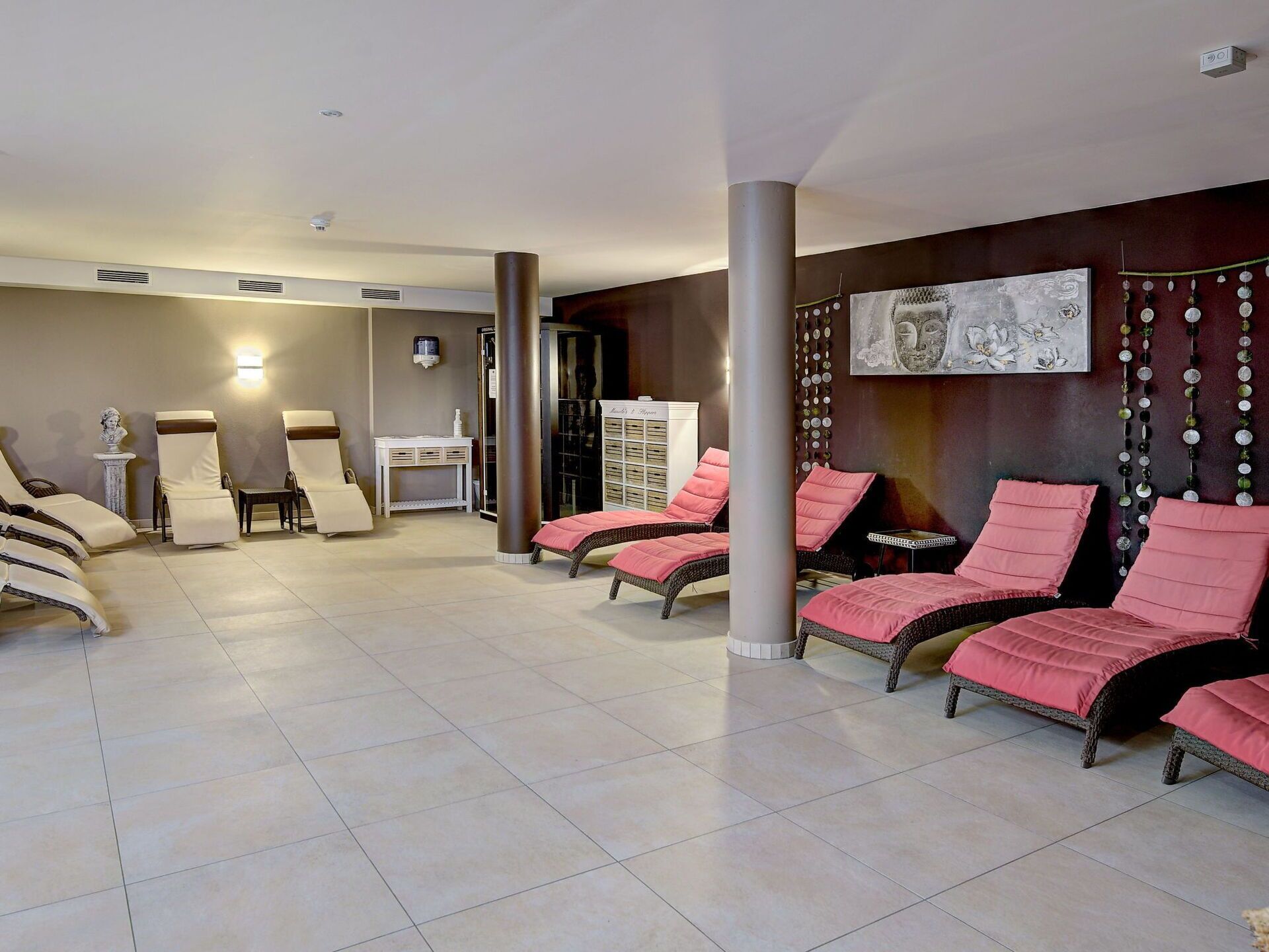 Ein Spa-Bereich mit Liegesesseln, einer Massageliege und einer Rezeption.
