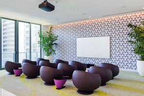 A conference room with a geometric patterned wall, a large whiteboard, and modern seating. - Luxury 3BR - Rooftop Pool - One Free Parking Spot (Miami)