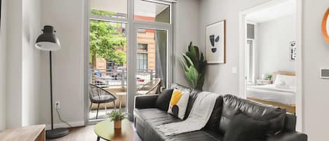 A modern living room with a leather sofa, a small round table, and a floor lamp.