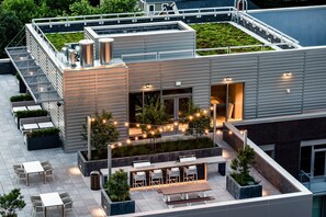 A rooftop terrace with outdoor seating, a bar area, and a staircase leading to an upper level. - Modern Apt Near DC & Metro | Pool & Gym (Arlington)