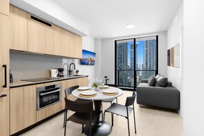 Eine moderne Küche mit Essbereich, einer Couch und einem großen Fenster mit Blick auf die Stadt.
