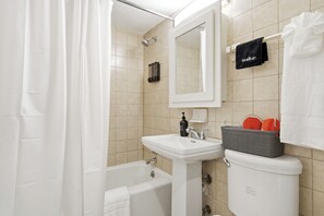 Un baño con bañera, lavabo, inodoro y espejo.