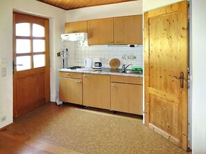 Eine Küche mit Holzausstattung, einer Mikrowelle, einer Kaffeemaschine und einem Spülbecken.