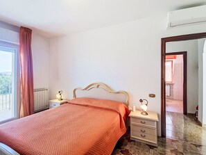 A bedroom with a bed, bedside tables, a mirror, and a view of the outside. - Lovely apartment for 5 guests with A/C, WIFI, TV, balcony, pets allowed and panoramic view (Pollutri)