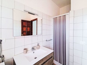 A bathroom with a white sink, mirror, and shower area. - Lovely apartment for 5 guests with A/C, WIFI, TV, balcony, pets allowed and panoramic view (Pollutri)