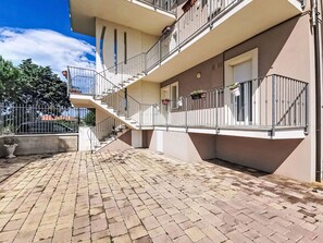 A multi-story building with a central staircase, balconies with railings, and potted plants. - Lovely apartment for 5 guests with A/C, WIFI, TV, balcony, pets allowed and panoramic view (Pollutri)