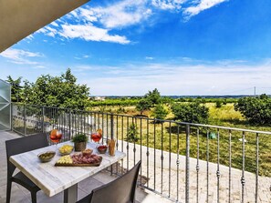 A terrace with a table set for a meal, a railing, and a view of a green landscape. - Lovely apartment for 5 guests with A/C, WIFI, TV, balcony, pets allowed and panoramic view (Pollutri)