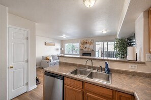 A modern kitchen with a dishwasher, double sink, and wooden cabinets. - Family 3BR/3.5BA W/ Cinema Near USAFA + Garden of the Gods (Colorado Springs)