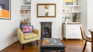 Un salon avec une cheminée, un canapé, une table basse et une bibliothèque.