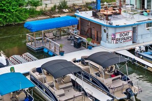 Un bote con un letrero que dice 'Boat Repairs' y una cubierta techada con asientos.