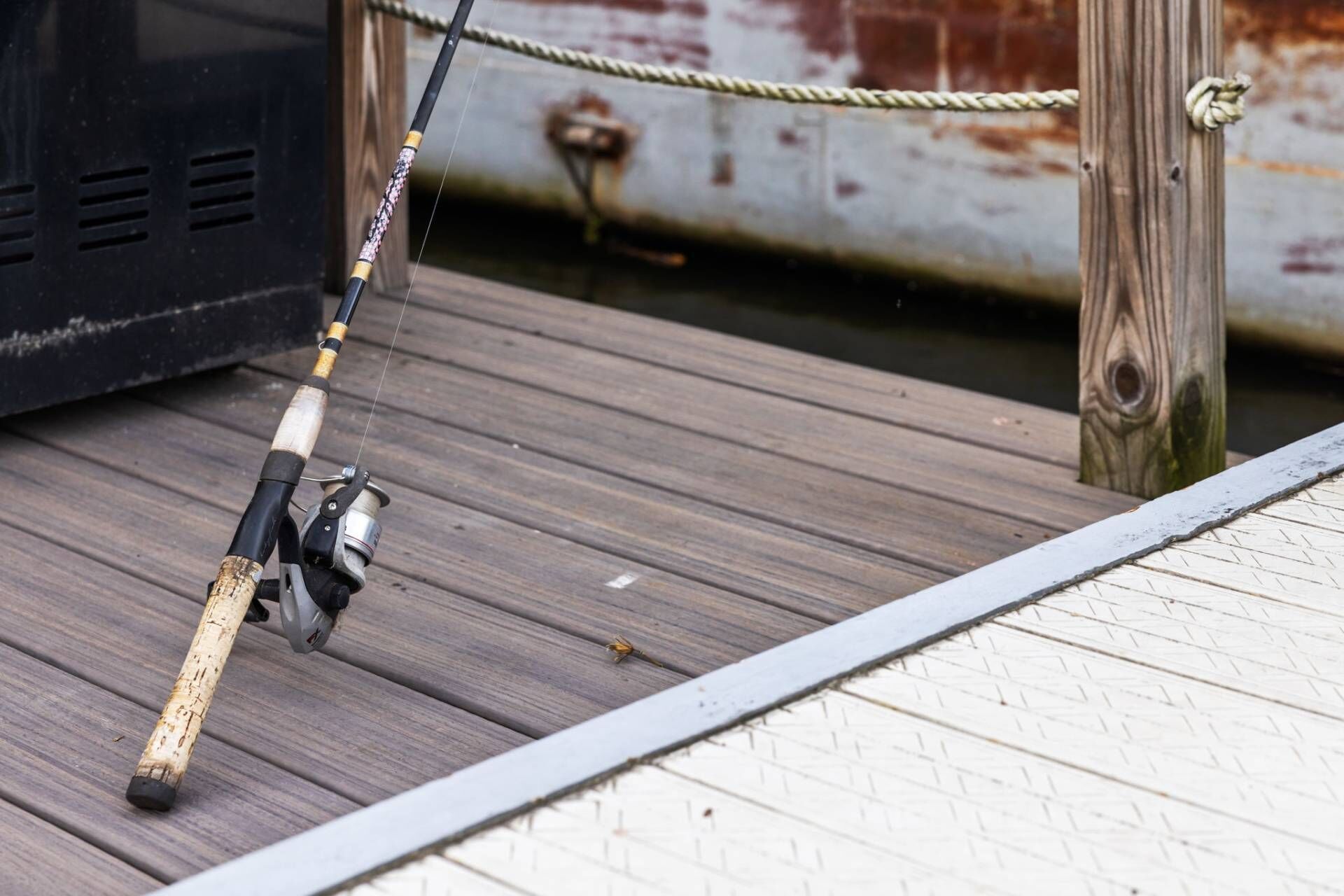 A fishing rod on a wooden dock.