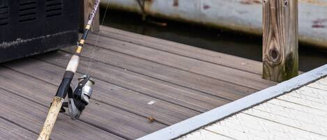 A fishing rod on a wooden dock.