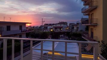 Ein Wohngebiet mit Gebäuden, einem Balkon und einem Sonnenuntergang.