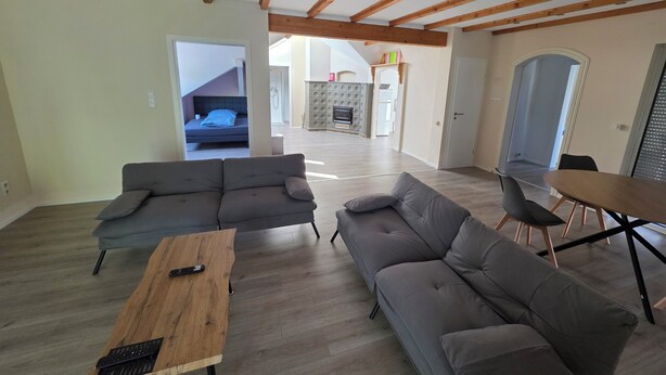 A spacious living area with a sofa set, a wooden coffee table, and a dining table with chairs. - Cozy and bright apartment in Lahde—in a quiet location, with a fully equipped kitchen (Petershagen)