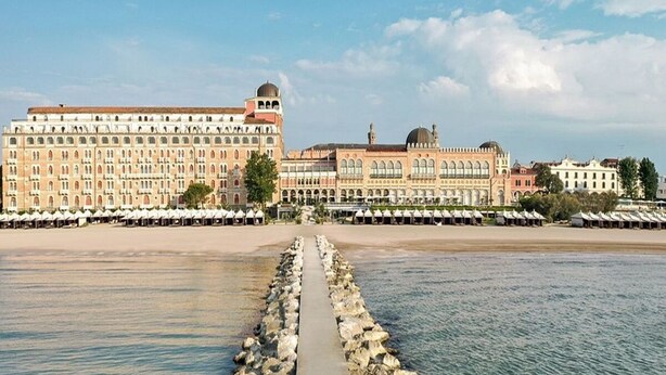 A waterfront hotel with a long promenade leading to the beach, featuring multiple buildings with classical architecture. - Stylish Lido Beach Apartment with Terrace, Shared Garden & Steps to the Sea (Lido)