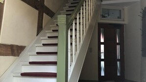 A staircase with white steps and red risers, leading to a door with frosted glass panels. - Golden Anchor Cozy Holiday Apartment in the Center of Rheinsberg (Rheinsberg)