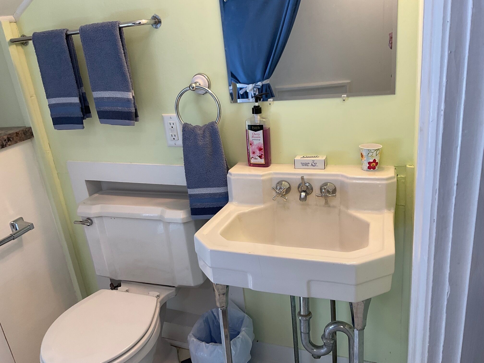 Un baño con inodoro, lavamanos y toallero.