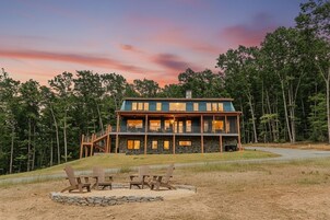 A two-story lodge with a stone facade, multiple windows, and a deck.