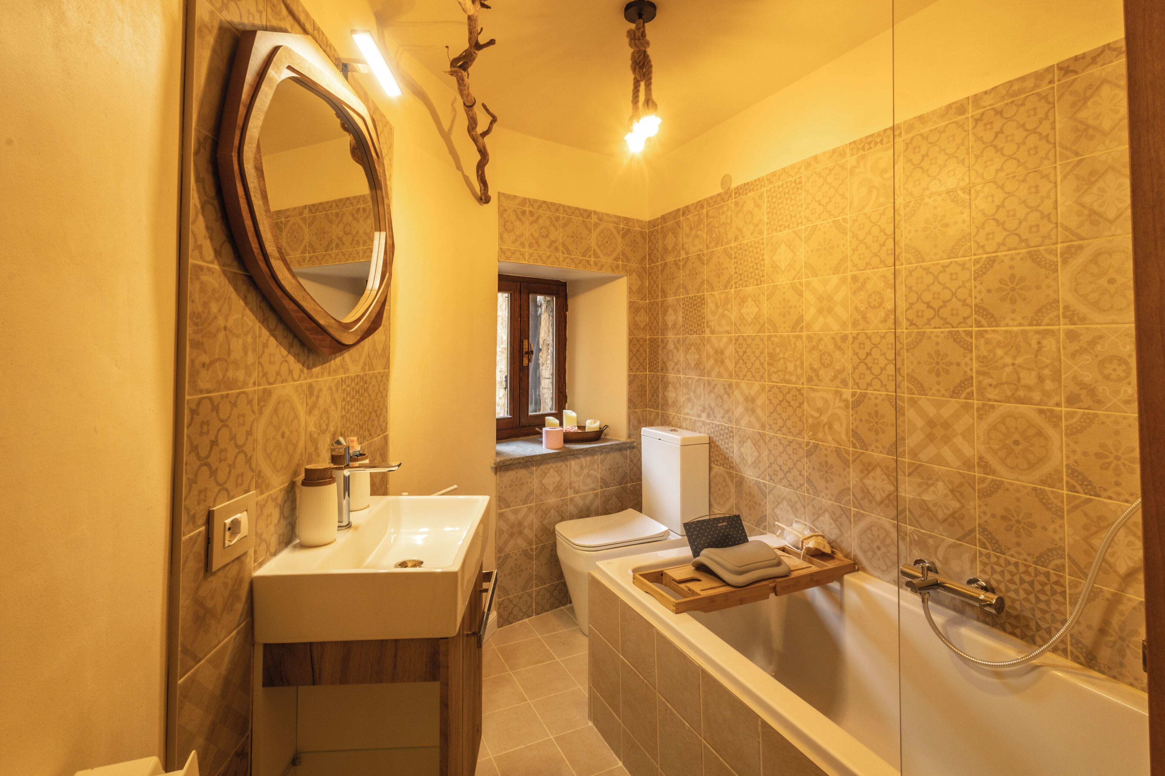 Une salle de bain équipée d’un lavabo, d’un miroir, de toilettes et d’une baignoire.