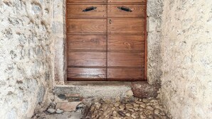 Eine Holztür, eine strukturierte Wand und ein Steinboden.