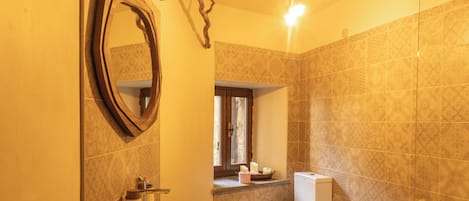 Un baño con bañera, inodoro, lavabo y espejo.