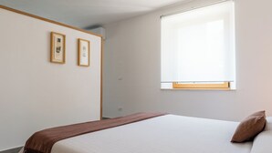 A bedroom with a bed, a window, and two framed pictures on the wall. - Platano, ADQ (Buje)
