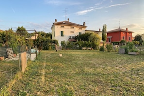 A residential area with houses, a fenced garden, and a clear sky.