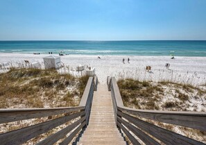 Eine Holztreppe führt zu einem Strand mit freiem Blick auf das Meer.