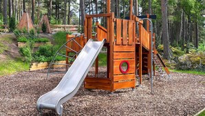 A playground with a slide, climbing structure, and a red circular element. - 3 Person Holiday Home in Fjardhundra (Fjärdhundra)
