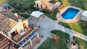Una propietat residencial amb piscina, terrassa coberta i una llar de pedra.