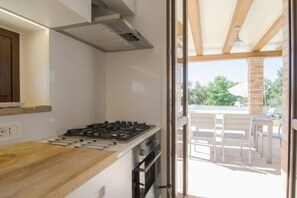 Una cocina con estufa a gas, horno y encimera de madera.