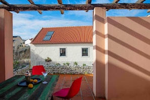 Un patio con una mesa, sillas y una casa al fondo.