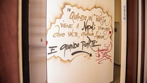 A wall with handwritten text in a foreign language, a door, and a hallway. - Holiday Home "Solemare Musica & Poesia" (napoli)