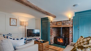 Una sala de estar acogedora con chimenea, televisor y asientos cómodos.