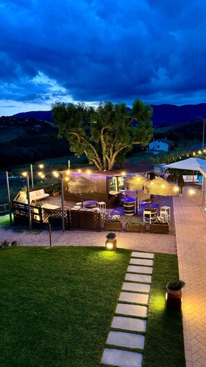 A deck with outdoor seating, a pathway, and a view of the landscape. - Agriturismo Agrileisuretime (Spoleto)