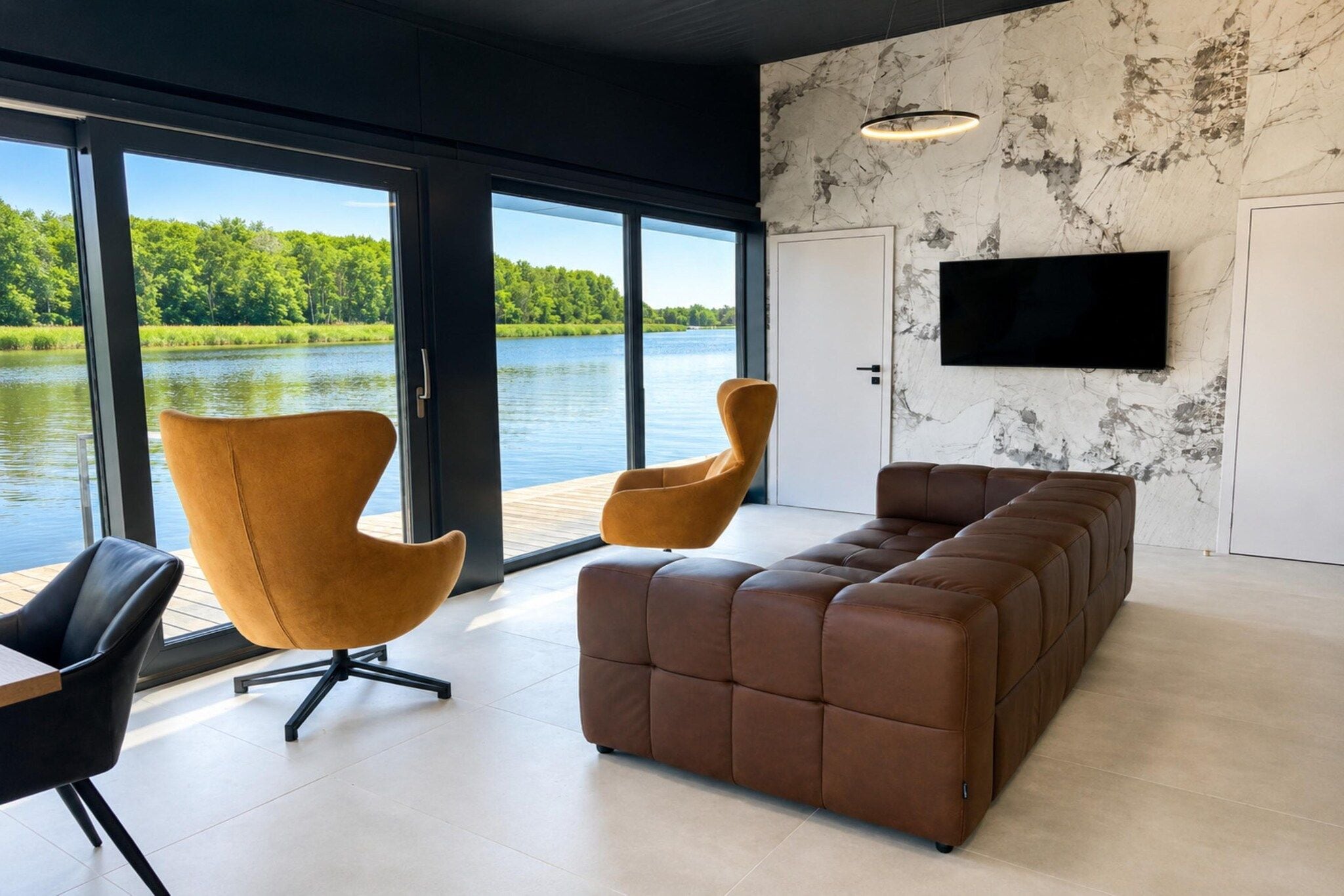 Un salon moderne doté d’une grande fenêtre, d’un canapé en cuir marron, de deux fauteuils de couleur moutarde et d’un téléviseur à écran plat fixé au mur.