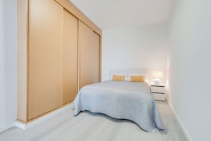 Ein Schlafzimmer mit Bett, Nachttischen, einem Schrank und einem Kleiderschrank.